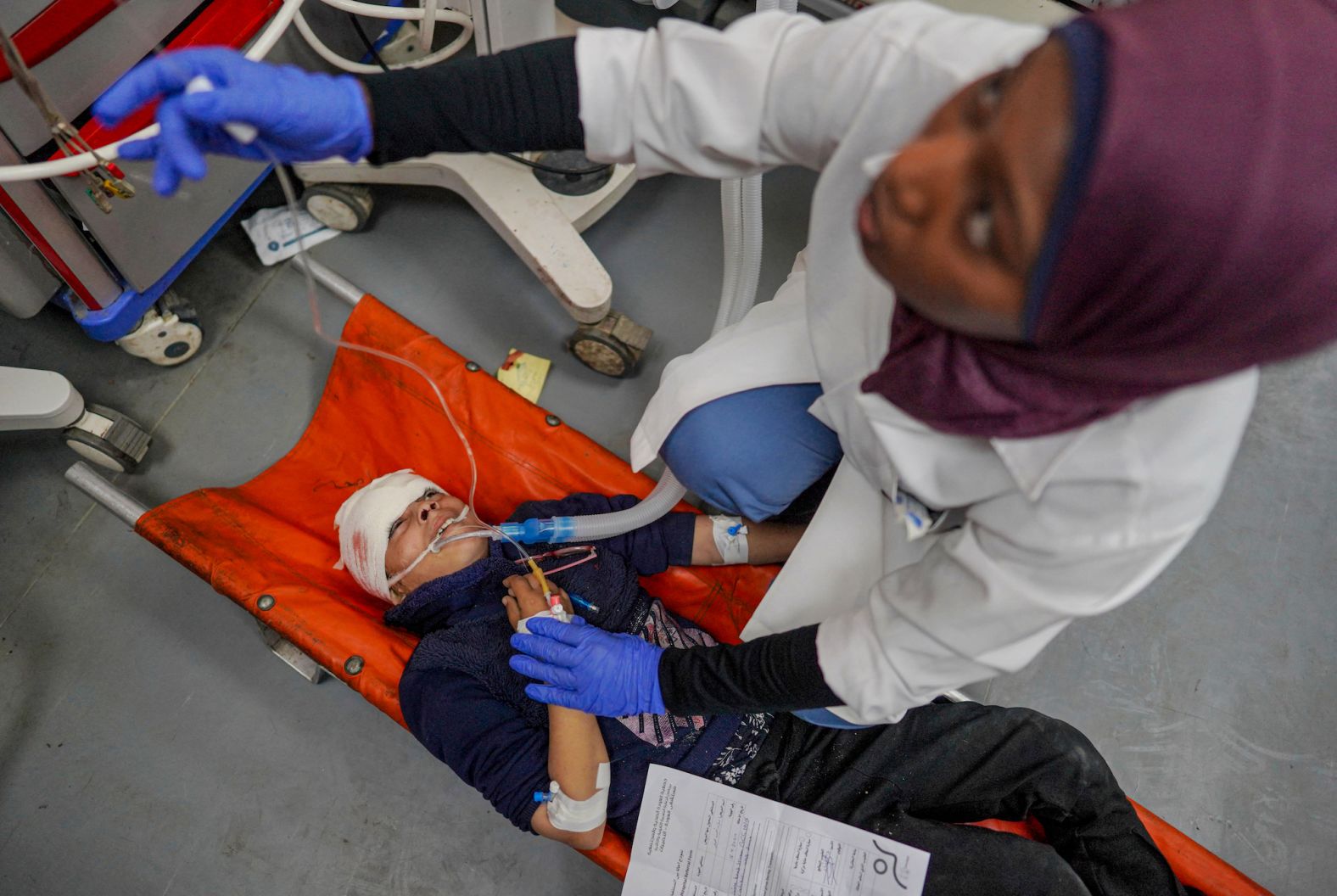 A medic gives first aid to an injured child at al-Aqsa Martyrs Hospital in Deir al-Balah, Gaza, on Tuesday, April 16.