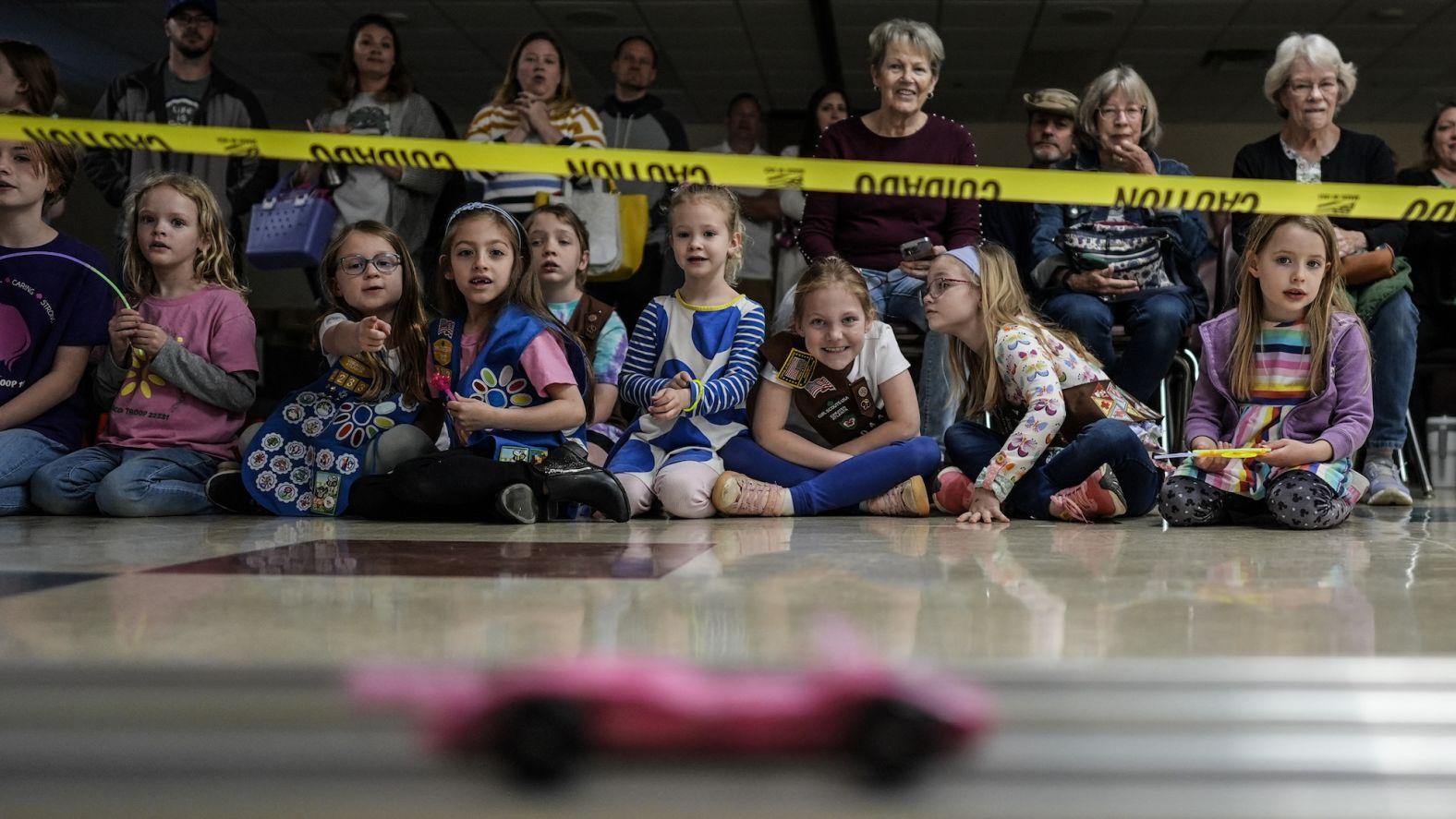 Girl Scout Daisies watch a car race during the Girl Scouts Pinewood Derby in Marietta, Georgia, on Saturday, April 13.