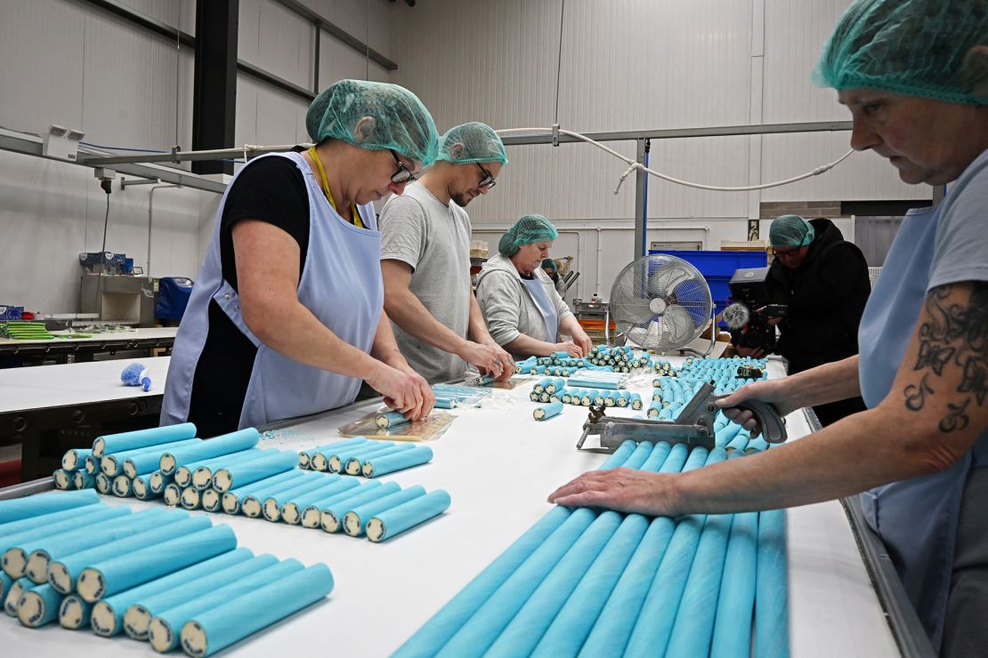 Workers use manual cutters to make sure sticks of rock are cut to the correct size in the factory at "Blackwoods of Blackpool" specialist producers of Blackpool rock in Blackpool, north west England on April 15, 2024. (Photo by Paul ELLIS / AFP) (Photo by PAUL ELLIS/AFP via Getty Images)