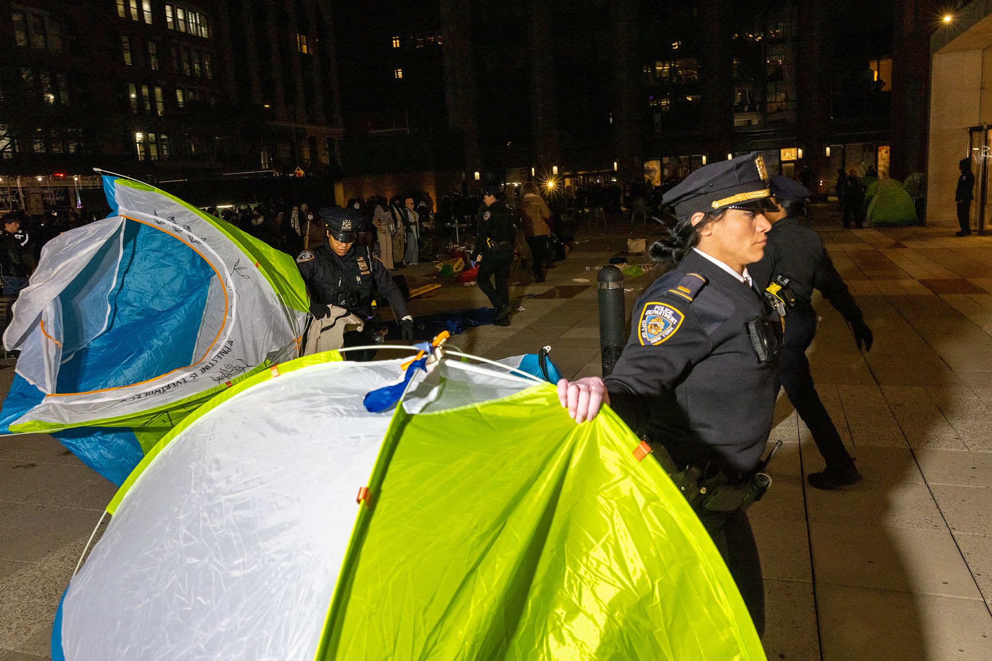 Police officers clear away tents from an encampment at New York University on April 22.