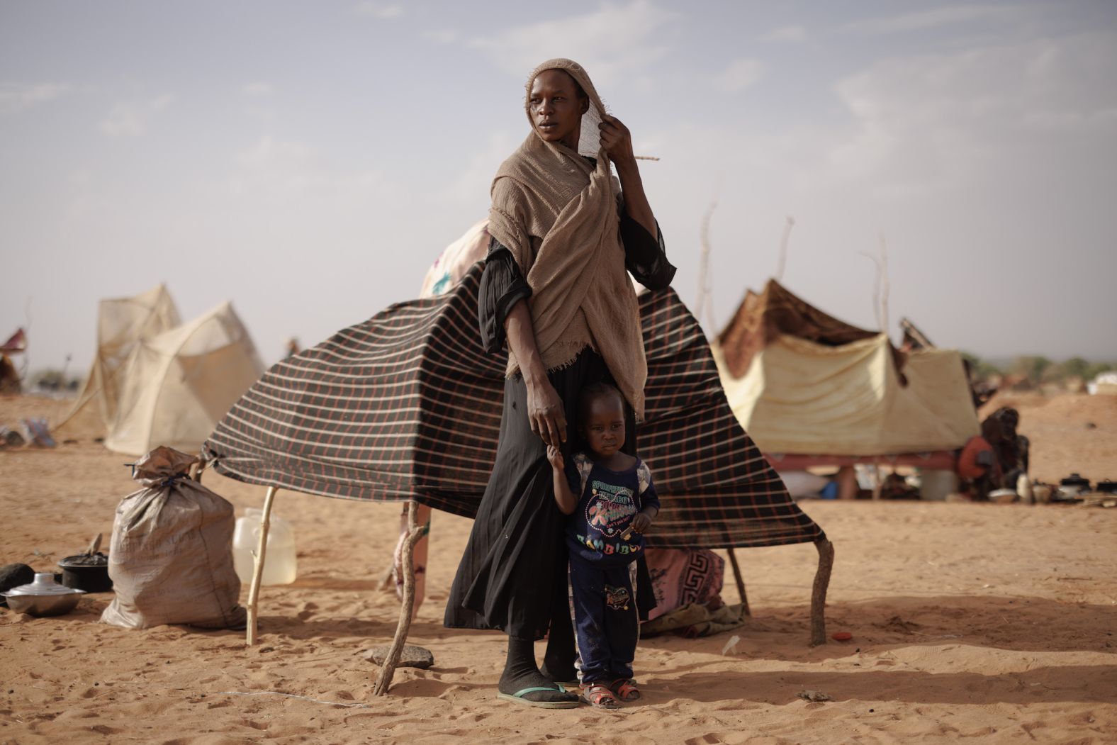 Refugees stand outside a makeshift shelter as a sandstorm approaches in Adre, Chad, on Sunday, April 21. <a href="https://www.cnn.com/2024/03/06/africa/hunger-crisis-rape-sudan-war-un-intl/index.html" target="_blank">The war in Sudan</a> has triggered a major hunger crisis in the country, and many have fled to neighboring Chad and South Sudan.