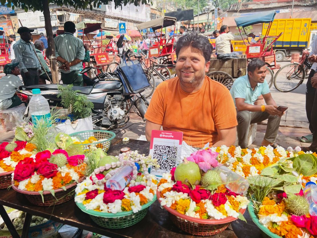 Kapil Sharma, 42, flower stall owner outside a temple in Old Delhi, with a QR code for customers