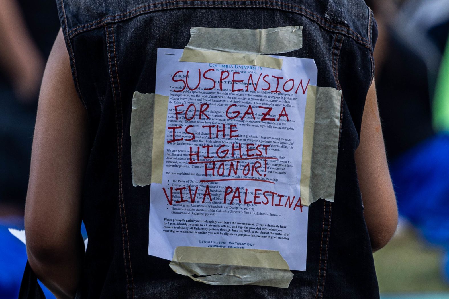 A protester at Columbia University wears the university's disciplinary notice on April 29.