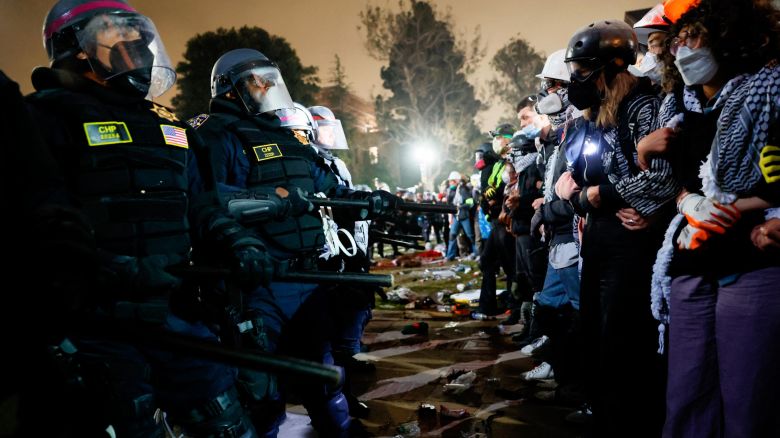 Police face-off with pro-Palestinian students after destroying part of the encampment barricade on the campus of the University of California, Los Angeles (UCLA) in Los Angeles, California, early on May 2, 2024. Police deployed a heavy presence on US university campuses on May 1 after forcibly clearing away some weeks-long protests against Israel's war with Hamas. Dozens of police cars patrolled at the University of California, Los Angeles campus in response to violent clashes overnight when counter-protesters attacked an encampment of pro-Palestinian students.