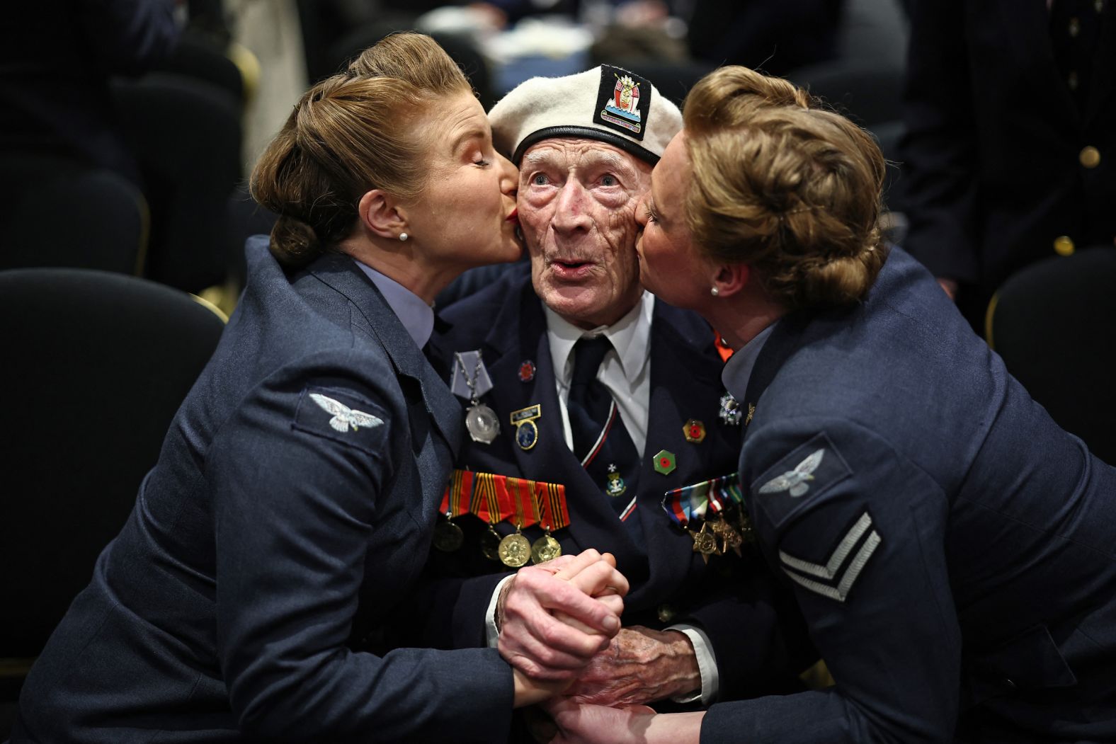 D-Day veteran Alec Penstone receives a kiss from two members of the D-Day Darlings, a song and dance group, during an event in London on Friday, April 26. This year marks the 80th anniversary of D-Day, the Allied amphibious landing that eventually led to victory in World War II.
