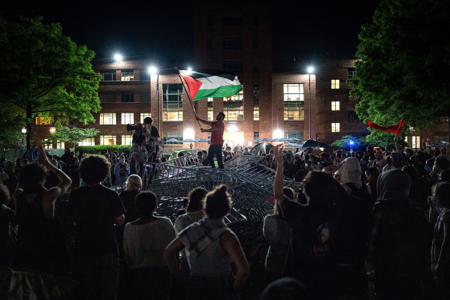 A man holds up a Palestinian flag during a protest at George Washington University in Washington, DC, on Monday, April 29.