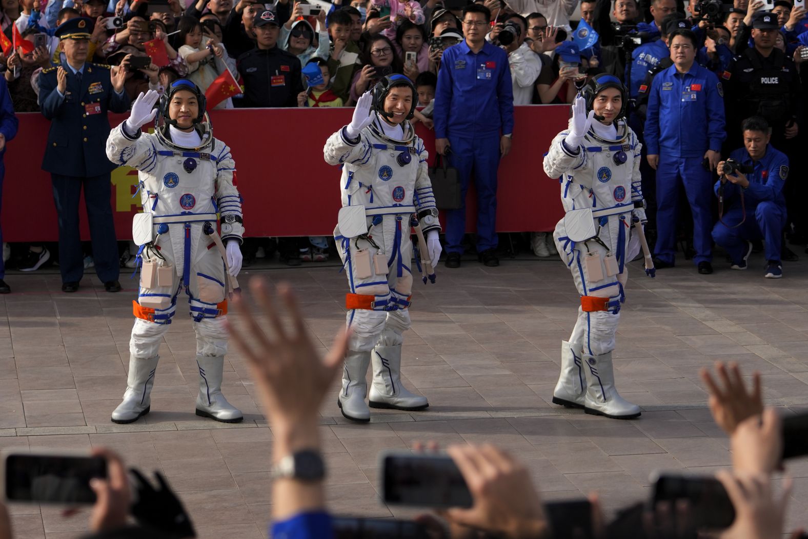 From left, Chinese astronauts Li Guangsu, Li Cong and Ye Guangfu wave to people before the start of their manned space mission Thursday, April 25, at the Jiuquan Satellite Launch Center in northwestern China. 