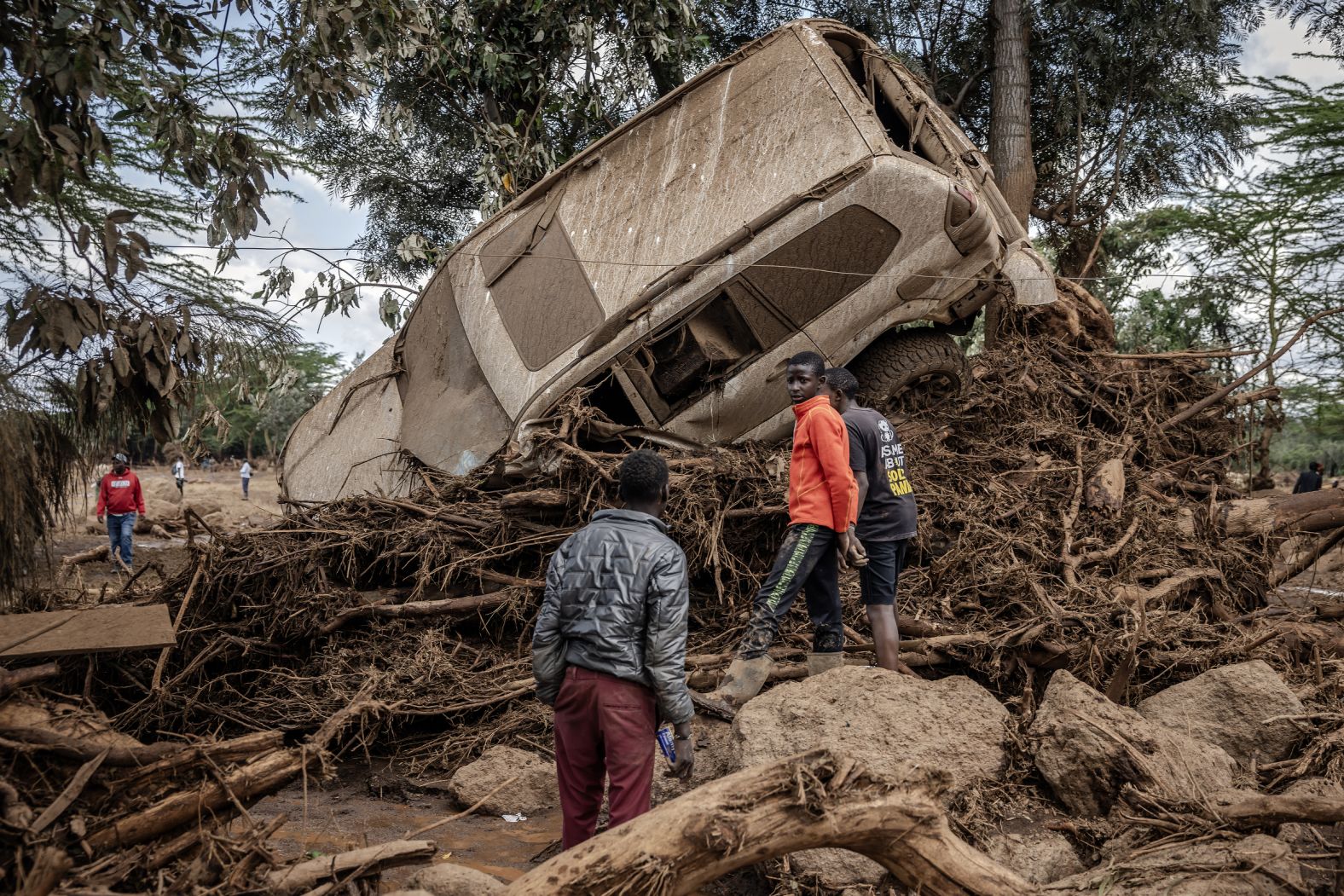 Young men inspect a vehicle that was damaged by floods in the Kenyan village of Kamuchiri on Monday, April 29. River Talek, one of the tributaries of the Mara River, burst its banks and swept through more than a dozen riverside tourist lodges and camps. At least 188 people were killed in the <a href="index.php?page=&url=https%3A%2F%2Fwww.cnn.com%2F2024%2F05%2F02%2Fafrica%2Fkenya-flooding-maasai-mara-intl%2Findex.html" target="_blank">catastrophic flooding</a>.