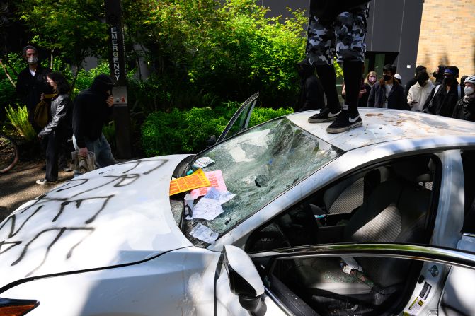 Protesters deface a car after a man <a href=