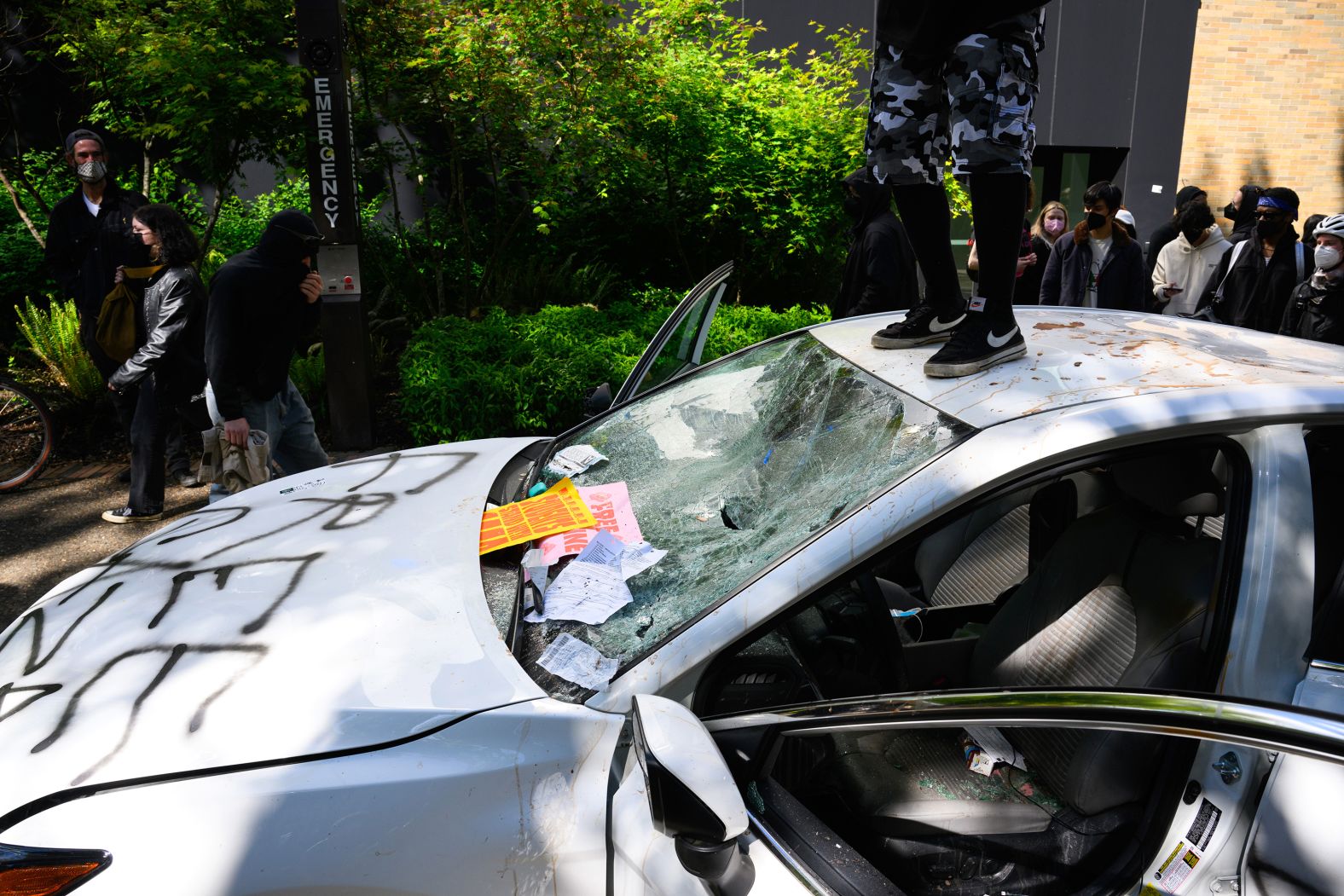 Protesters deface a car after a man <a href="index.php?page=&url=https%3A%2F%2Fwww.cnn.com%2Fbusiness%2Flive-news%2Funiversity-protests-pro-palestinian-israel-05-03-24%2Fh_c36dd0758d17e63f2dd99839d08086aa" target="_blank">drove it toward a crowd</a> at Portland State University on May 2. The driver stopped just short of a group of protesters and sprayed them with "some kind of pepper spray," police said.