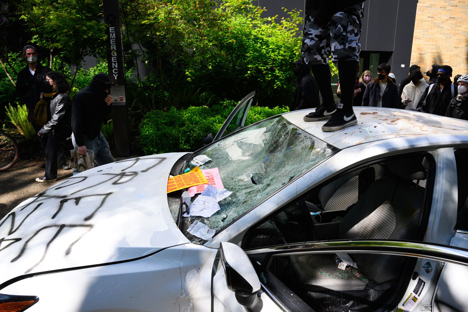 Protesters deface a car after a man <a href="https://www.cnn.com/business/live-news/university-protests-pro-palestinian-israel-05-03-24/h_c36dd0758d17e63f2dd99839d08086aa" target="_blank">drove it toward a crowd</a> at Portland State University in Portland on May 2. The driver stopped just short of a group of protesters and sprayed them with "some kind of pepper spray," police said.