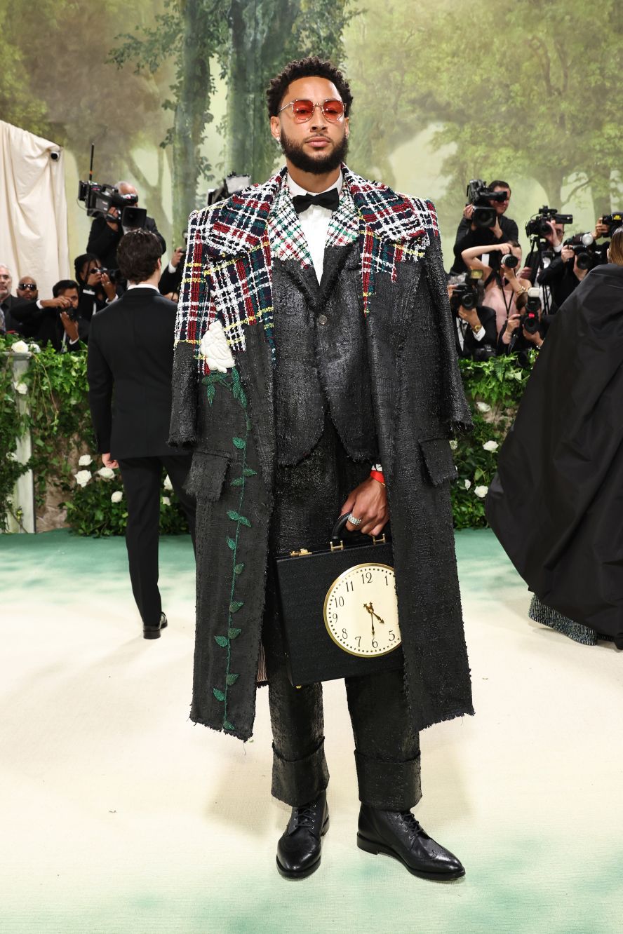 Brooklyn Nets player Ben Simmons wore a black and tartan tweed coat, embroidered with one large white rose, and in a very literal reference, clutched a small briefcase with a clock face on its front. 