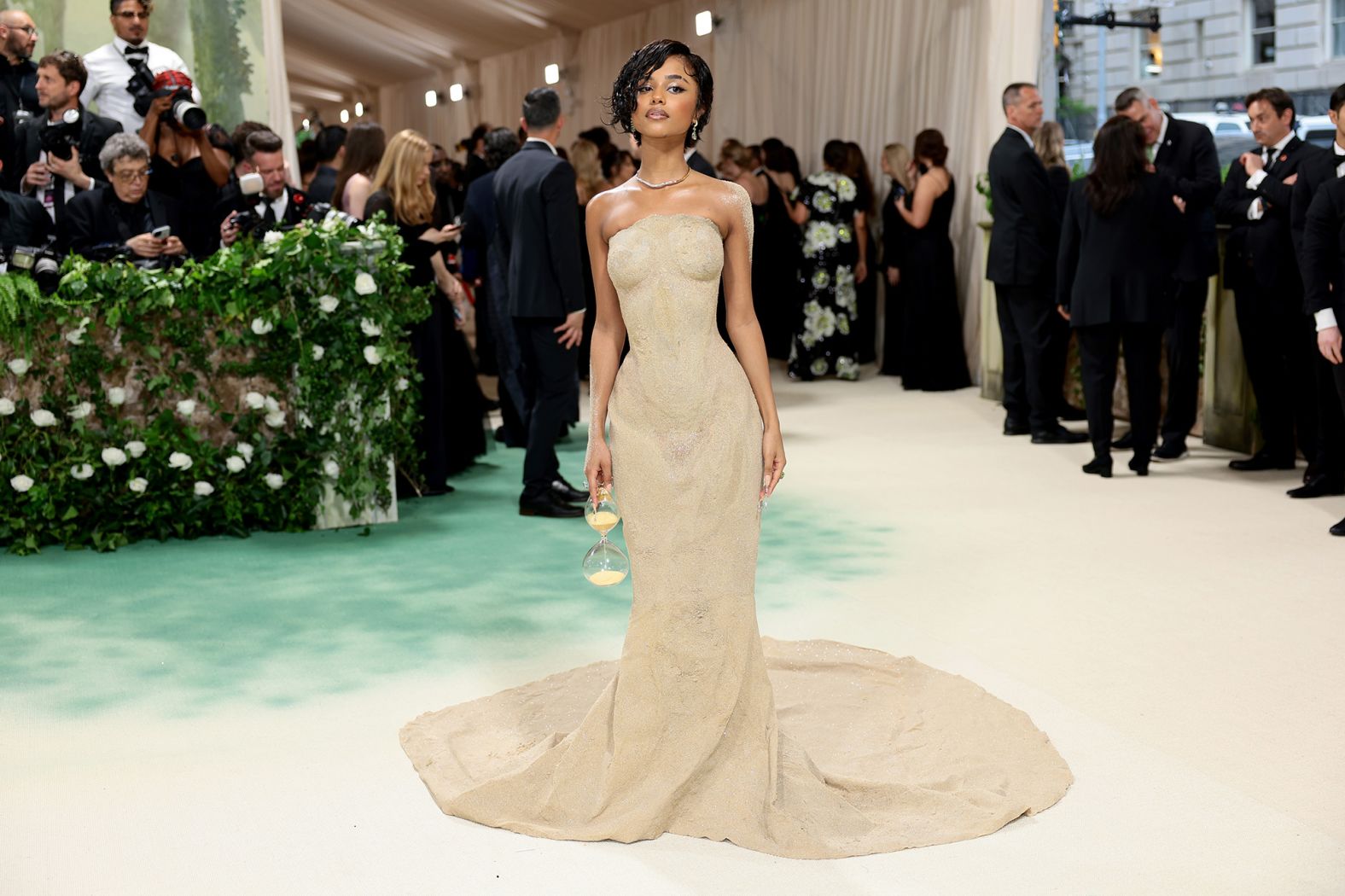The organza train on Tyla's custom Balmain gown was encased with three shades of sand mixed with micro crystal studs for depth and sparkle. Her clutch was a literal hourglass.