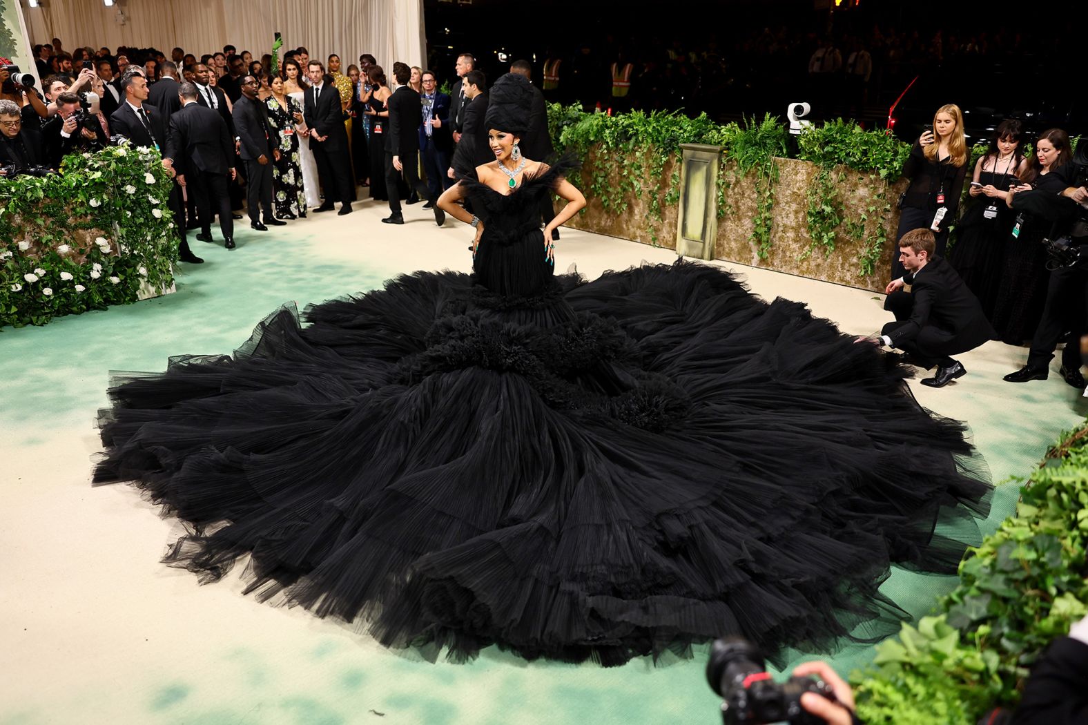 Cardi B brought the drama in a black dress by Giambattista Valli with overflowing waves of fabric, perhaps in reference to the oncoming mob in J.G. Ballard's dystopian tale, or themes of death and decay. She joked that the dress weighs five pounds more than she does. 