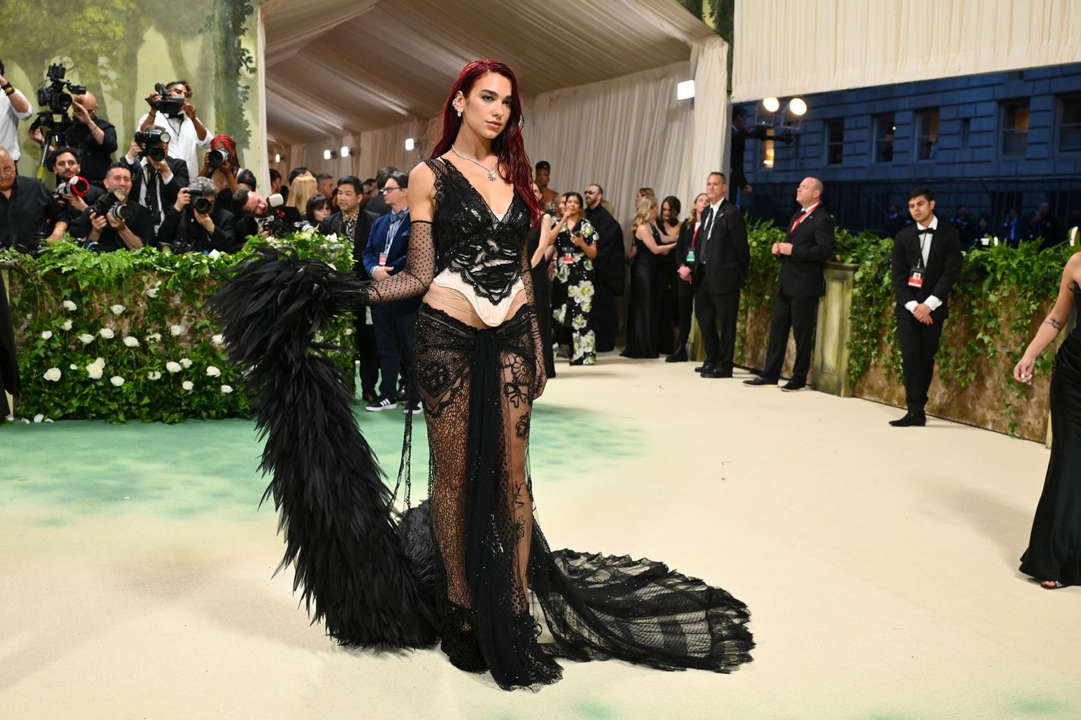 Dua Lipa in a vampy Marc Jacobs number that trails with a raven-esque,  feathery train. 