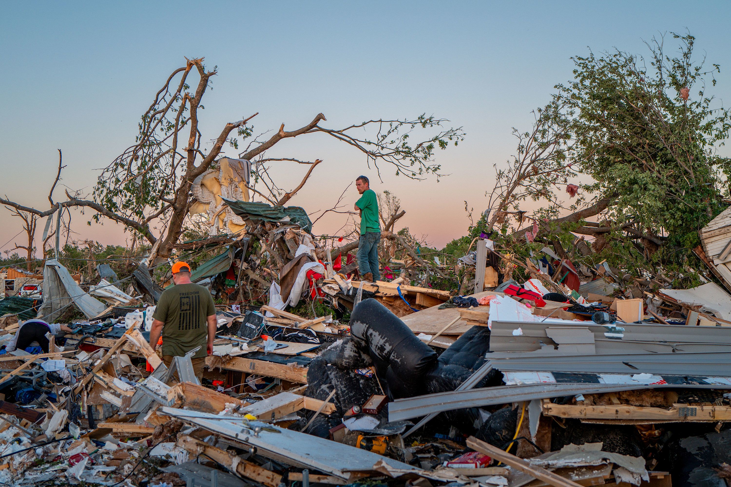 The Crowder family surveys what's left of their home Tuesday, May 7, after a tornado in Barnsdall, Oklahoma.