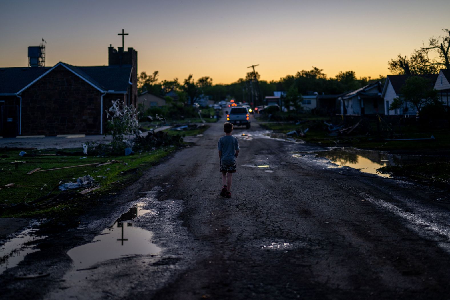A child walks through a tornado-damaged neighborhood in Barnsdall, Oklahoma, on Tuesday, May 7.