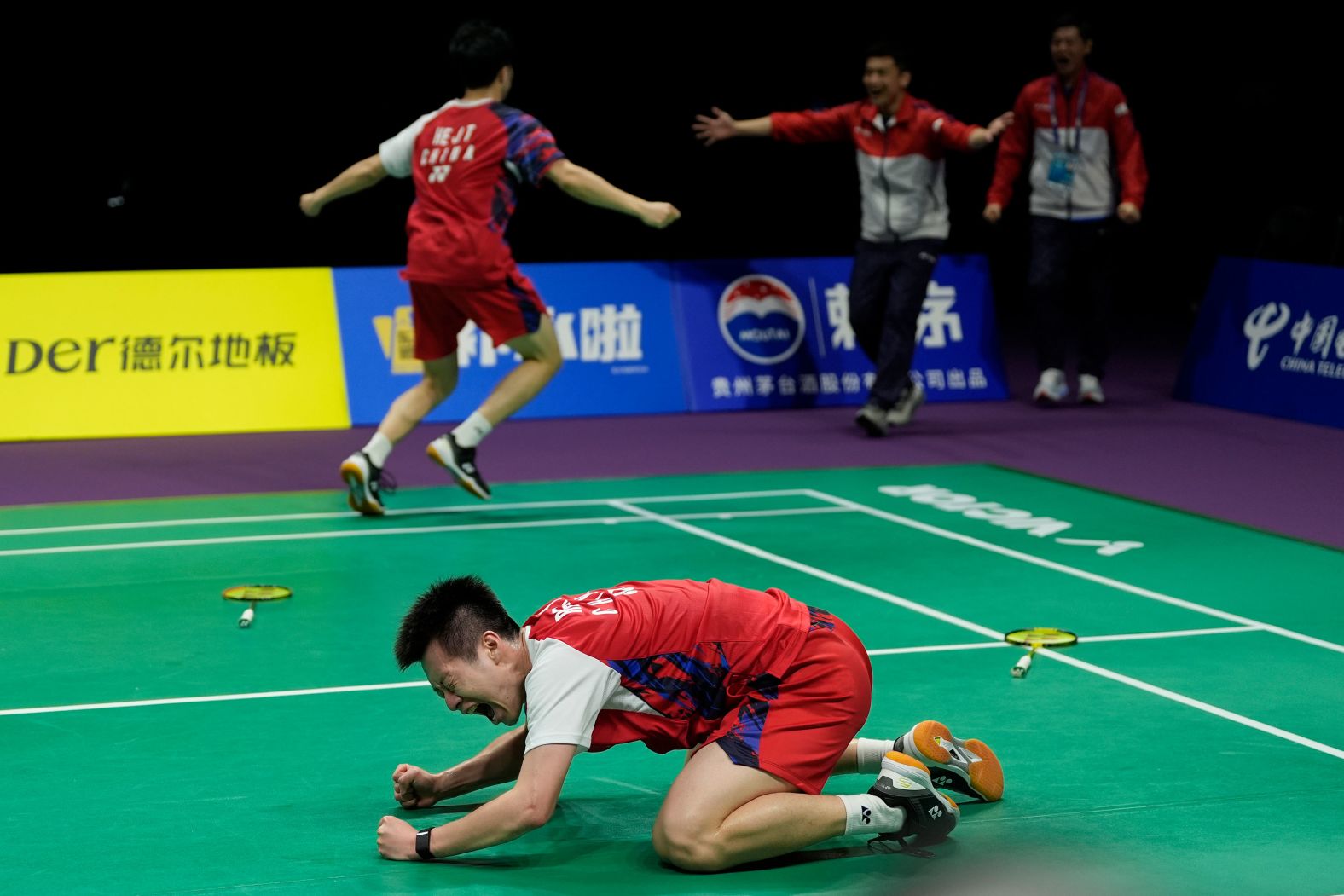 Chinese badminton player He Jiting runs to hug his coaches as Ren Xiangyu, foreground, celebrates on the court after they defeated an Indonesian team in the final of the Thomas Cup on Sunday, May 5. 