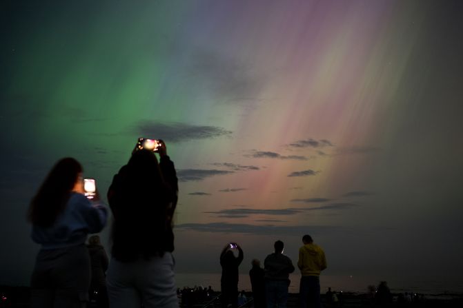 People photograph the northern lights from Whitley Bay, England, on May 10.