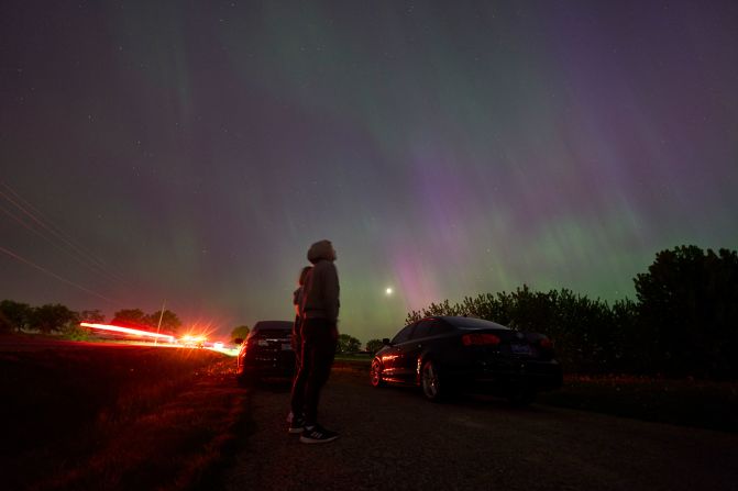 People stop along a country road near London, Ontario, to view the aurora borealis on May 10. Auroras are often observed in Canada's northern regions, but rarely in southern Ontario.