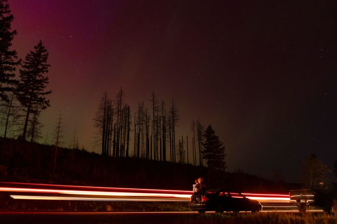 In this long exposure photo, cars pass by as people look at the night sky towards the northern lights in Estacada, Oregon, on May 10.