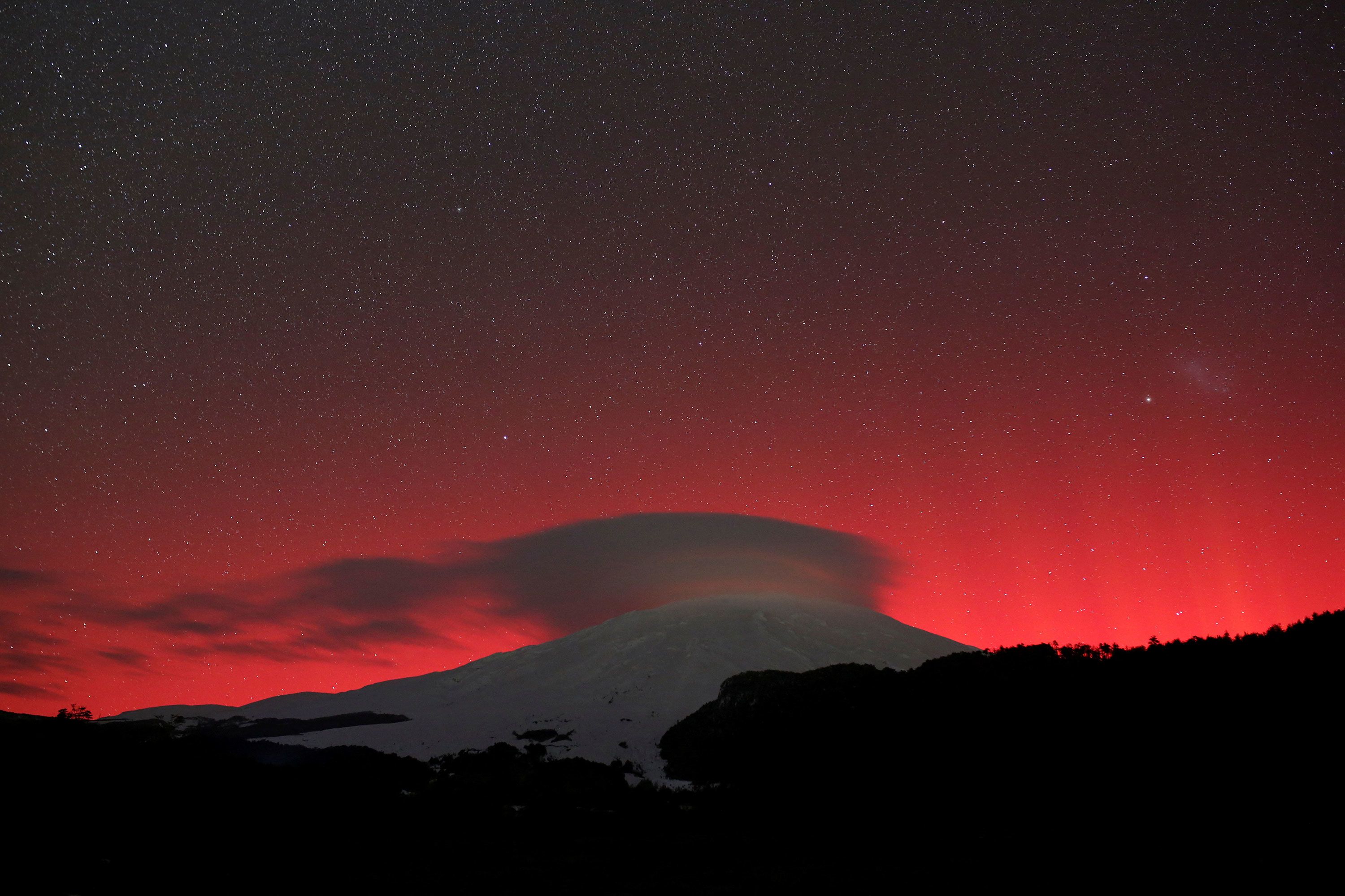 Aurora australis, or the southern lights, glow over Villarrica volcano in Pucón, Chile, on May 10.