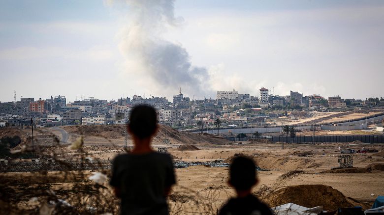 Boys watch smoke billowing during Israeli strikes east of Rafah in the southern Gaza Strip on May 13, 2024.