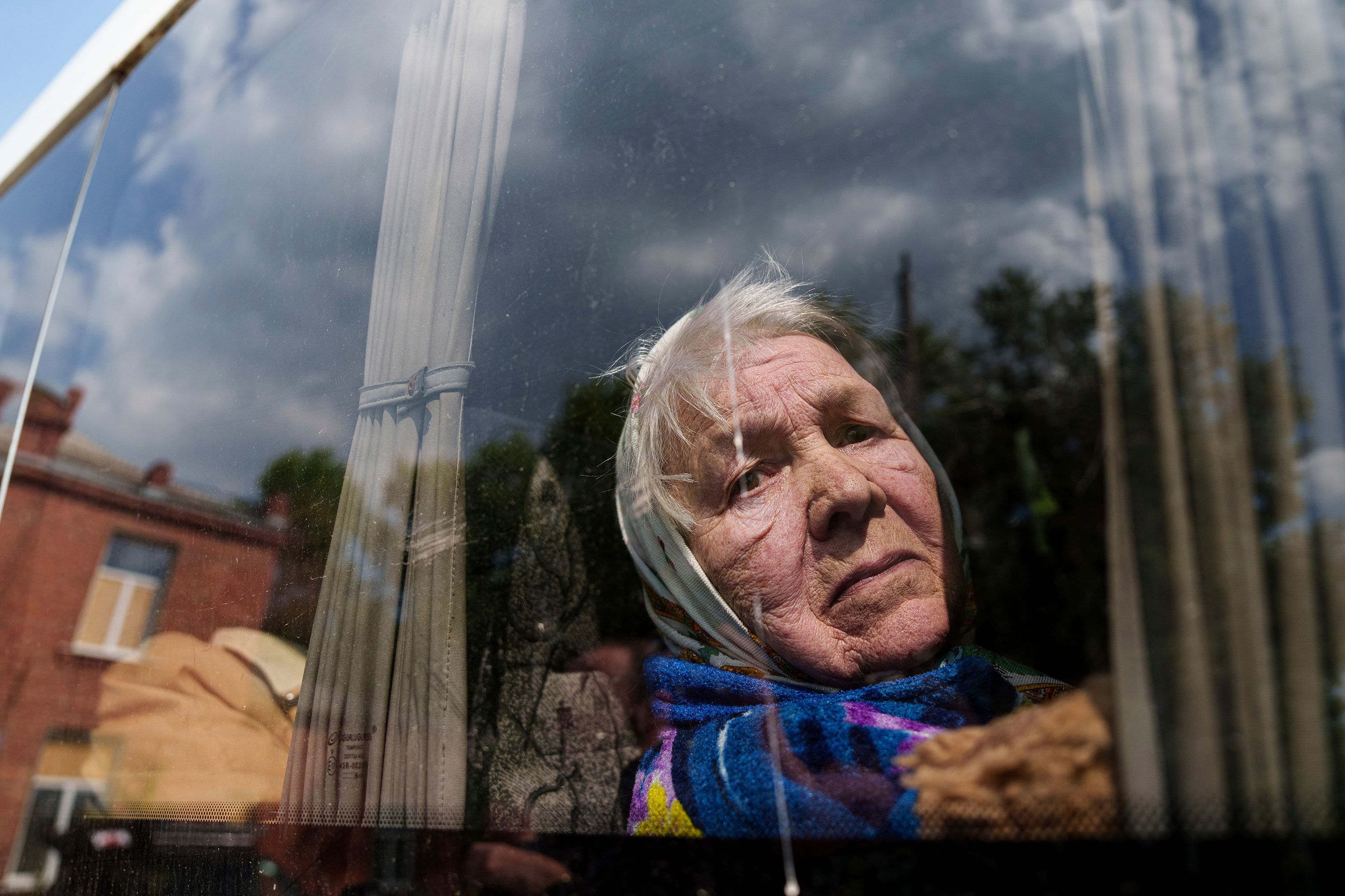 Liudmila, 85, looks though the window of a bus after being evacuated from Vovchansk, Ukraine.