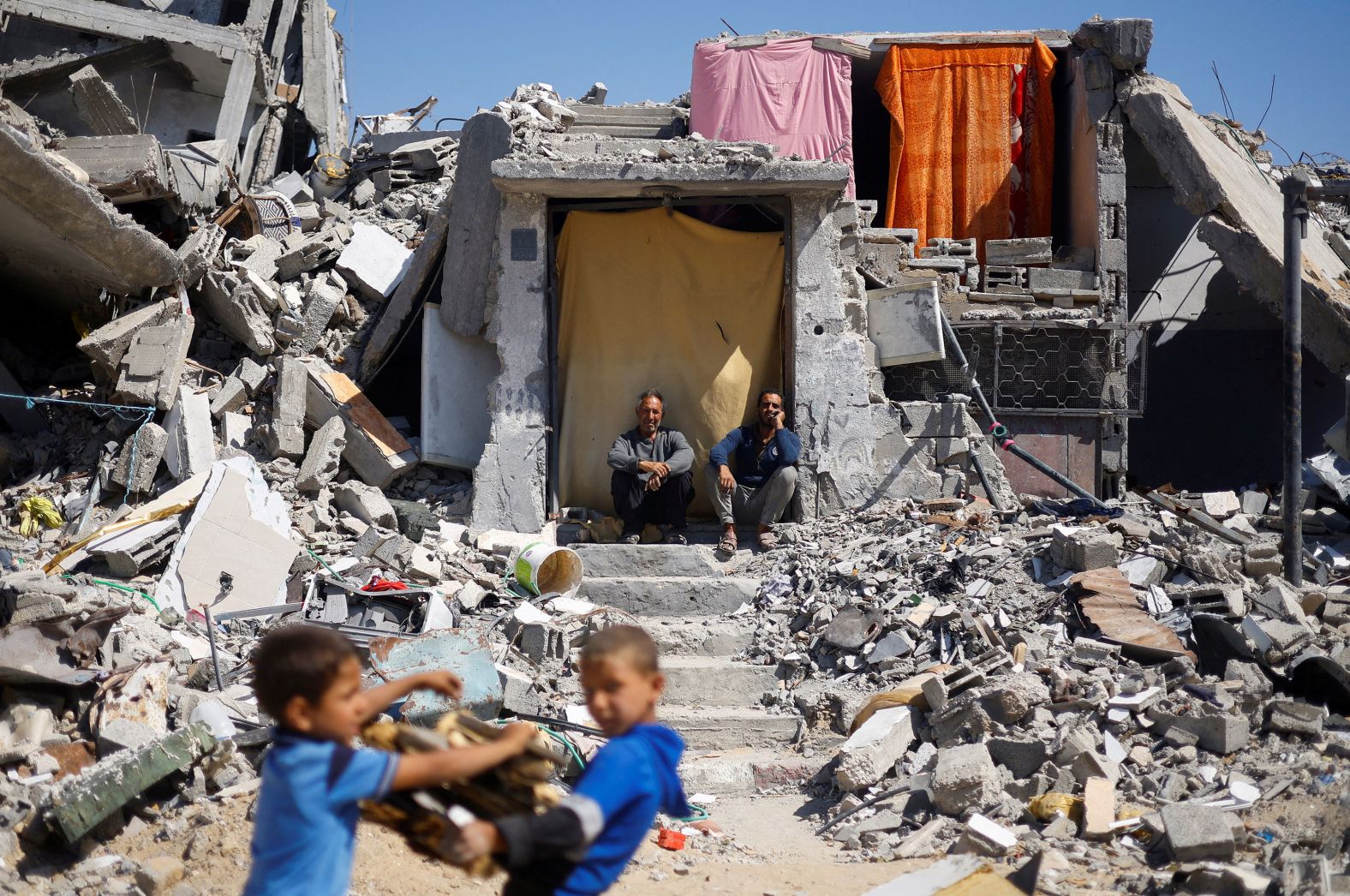 Palestinians sit at their house in Khan Younis, Gaza, on Tuesday, May 14. It had been destroyed in an Israeli strike. Months of fierce fighting in Khan Younis <a href="index.php?page=&url=https%3A%2F%2Fwww.cnn.com%2F2024%2F04%2F07%2Fmiddleeast%2Fisrael-khan-younis-withdrawal-gaza-intl%2Findex.html" target="_blank">have left much of the city in ruins</a>.