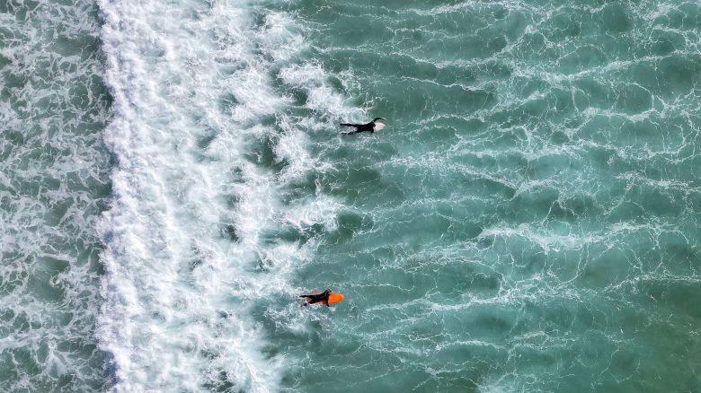 A drone view shows people surfing during spring sunshine, as the warm weather is set to continue into the weekend, at Fistral Beach, Newquay, south west Britain, May 9, 2024. REUTERS/Toby Melville     TPX IMAGES OF THE DAY