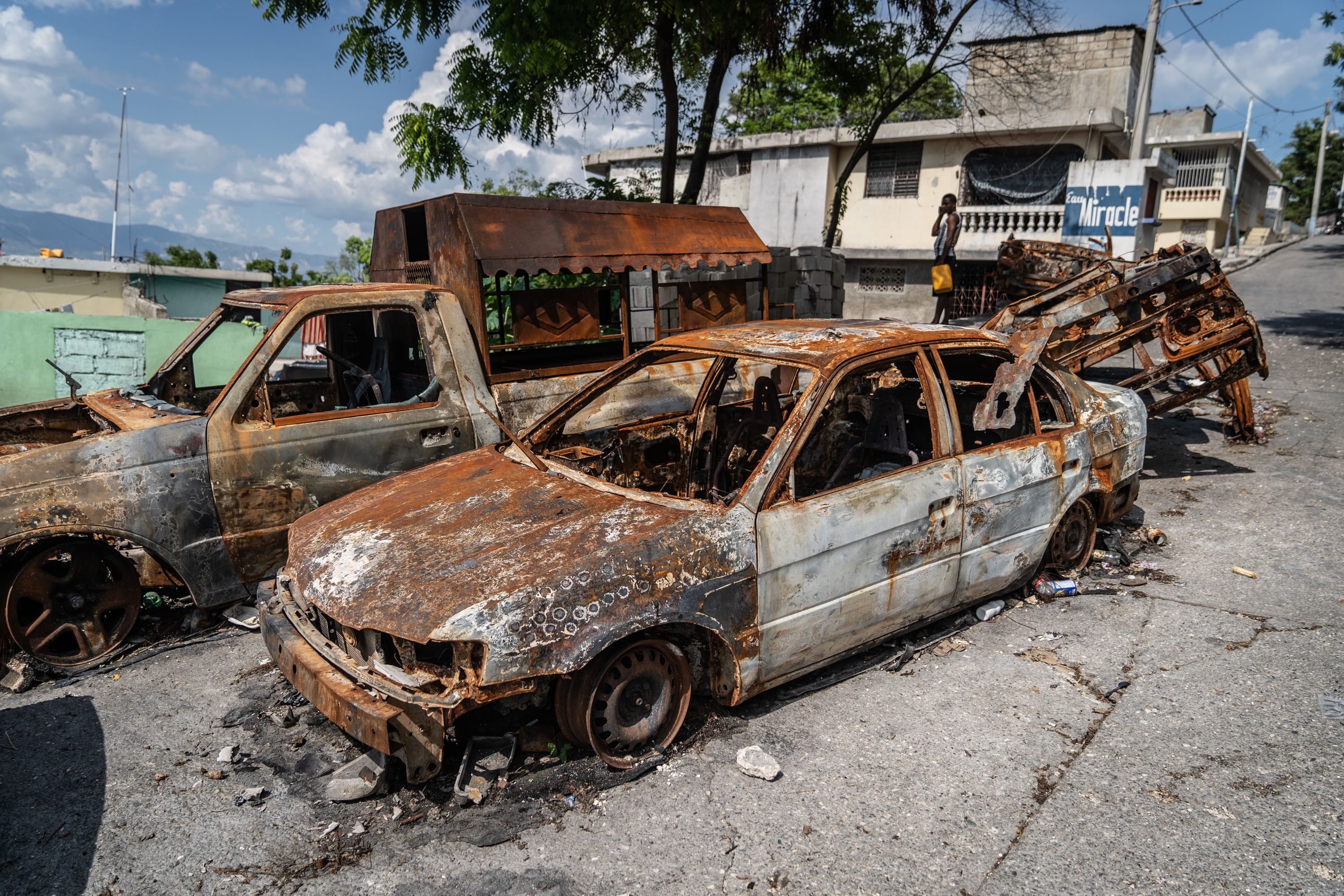 Burnt-out vehicles line a roadside in the Solino neighborhood of Port-au-Prince. Residents living nearby say that this street was the scene of a bloody gun battle between gang members and the Haitian National Police in March.