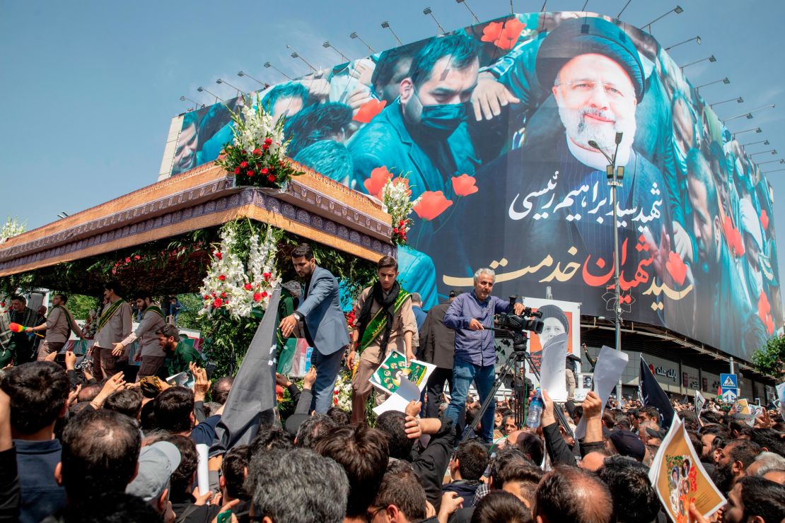 Iranians follow a truck carrying coffins of the late President Ebrahim Raisi and his companions, who were killed in a helicopter crash, during a funeral ceremony for them on May 22, 2024 in Tehran, Iran.