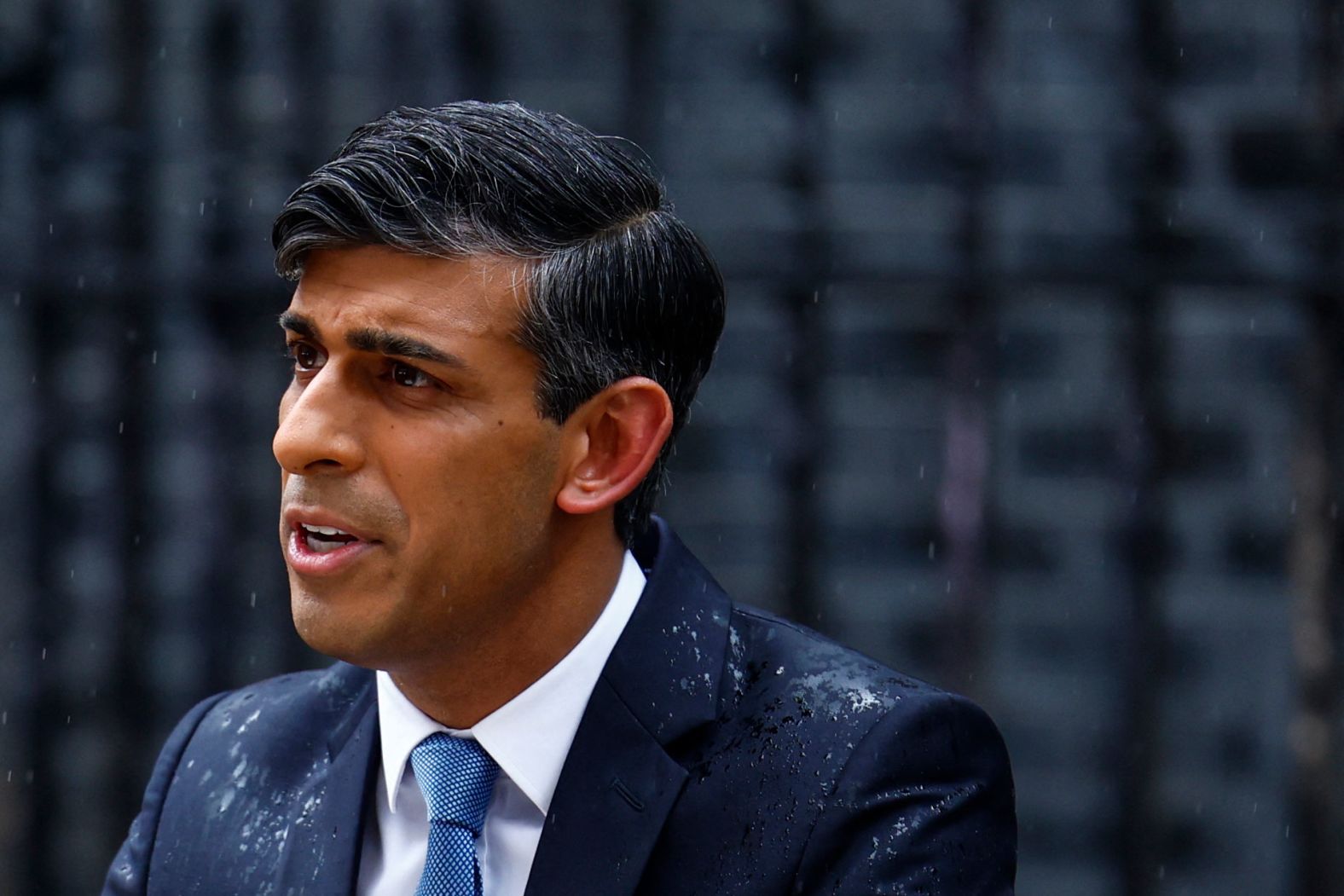 British Prime Minister Rishi Sunak, soaked by rain, delivers a statement outside Downing Street in London on Wednesday, May 22. <a href="index.php?page=&url=https%3A%2F%2Fwww.cnn.com%2F2024%2F05%2F22%2Fuk%2Fuk-early-elections-sunak-conservatives-intl%2Findex.html" target="_blank">Sunak announced a snap general election for July 4</a> as his Conservative Party faces an uphill struggle to extend its 14 years in power. Sunak was required to hold a vote by January 2025.