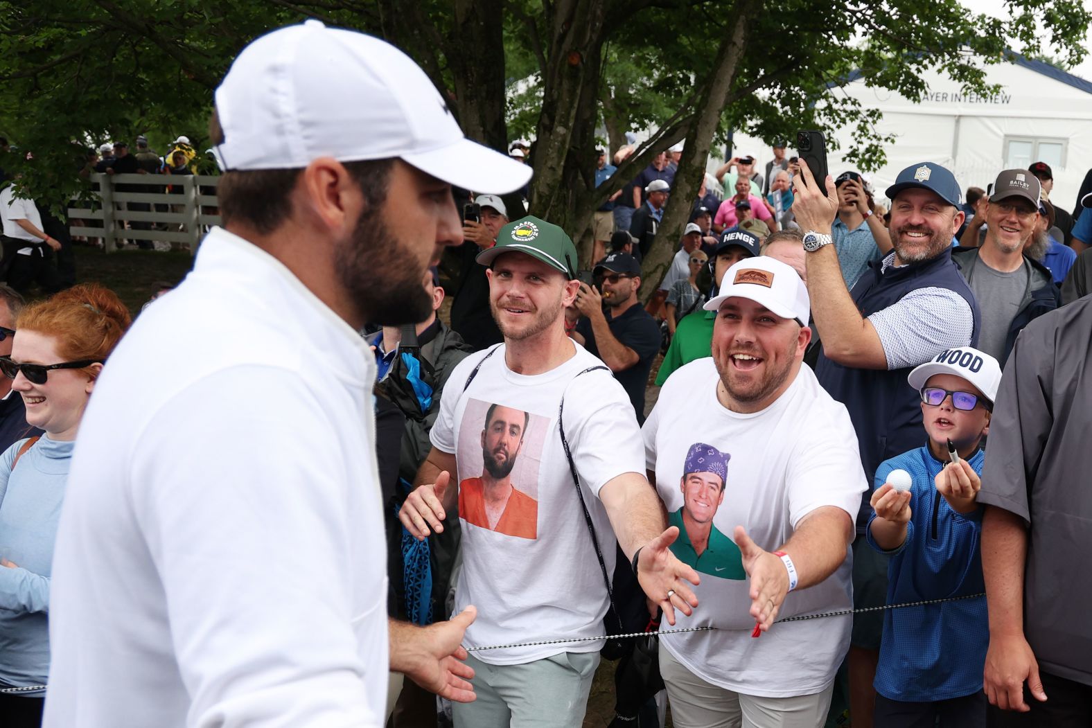 Scottie Scheffler, the world's top-ranked golfer, greets fans wearing T-shirts of him during the second round of the PGA Championship on Friday, May 17. Earlier that day, <a href="index.php?page=&url=https%3A%2F%2Fwww.cnn.com%2F2024%2F05%2F22%2Fsport%2Fpolice-officials-charges-against-golfer-scottie-scheffler%2Findex.html" target="_blank">Scheffler was arrested</a> in Louisville, Kentucky, after reportedly trying to drive around the scene of a fatal crash near the Valhalla Golf Club. Scheffler was charged with felony second-degree assault on a police officer, along with lesser charges of third-degree criminal mischief, reckless driving and disregarding signals from officers directing traffic, according to Jefferson County court records. In a statement last week, Scheffler said he proceeded as directed and "there was a big misunderstanding of what I thought I was being asked to do." His attorney has said <a href="index.php?page=&url=https%3A%2F%2Fwww.cnn.com%2F2024%2F05%2F23%2Fus%2Fscottie-scheffler-arrest-update-louisville%2Findex.html" target="_blank">Scheffler plans to plead not guilty</a> to the charges.