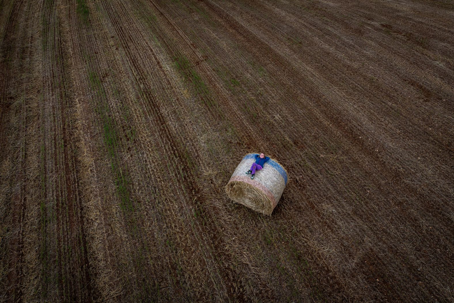 Lilith, 6, rests on a freshly harvested alfalfa bale near Vilademuls, Spain, on Saturday, May 18.