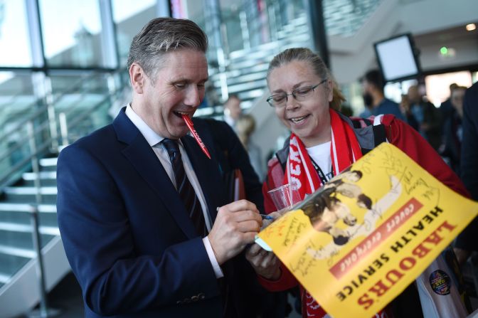 Starmer signs a poster for a delegate during the Labour Party Conference in Liverpool, England, in September 2018.