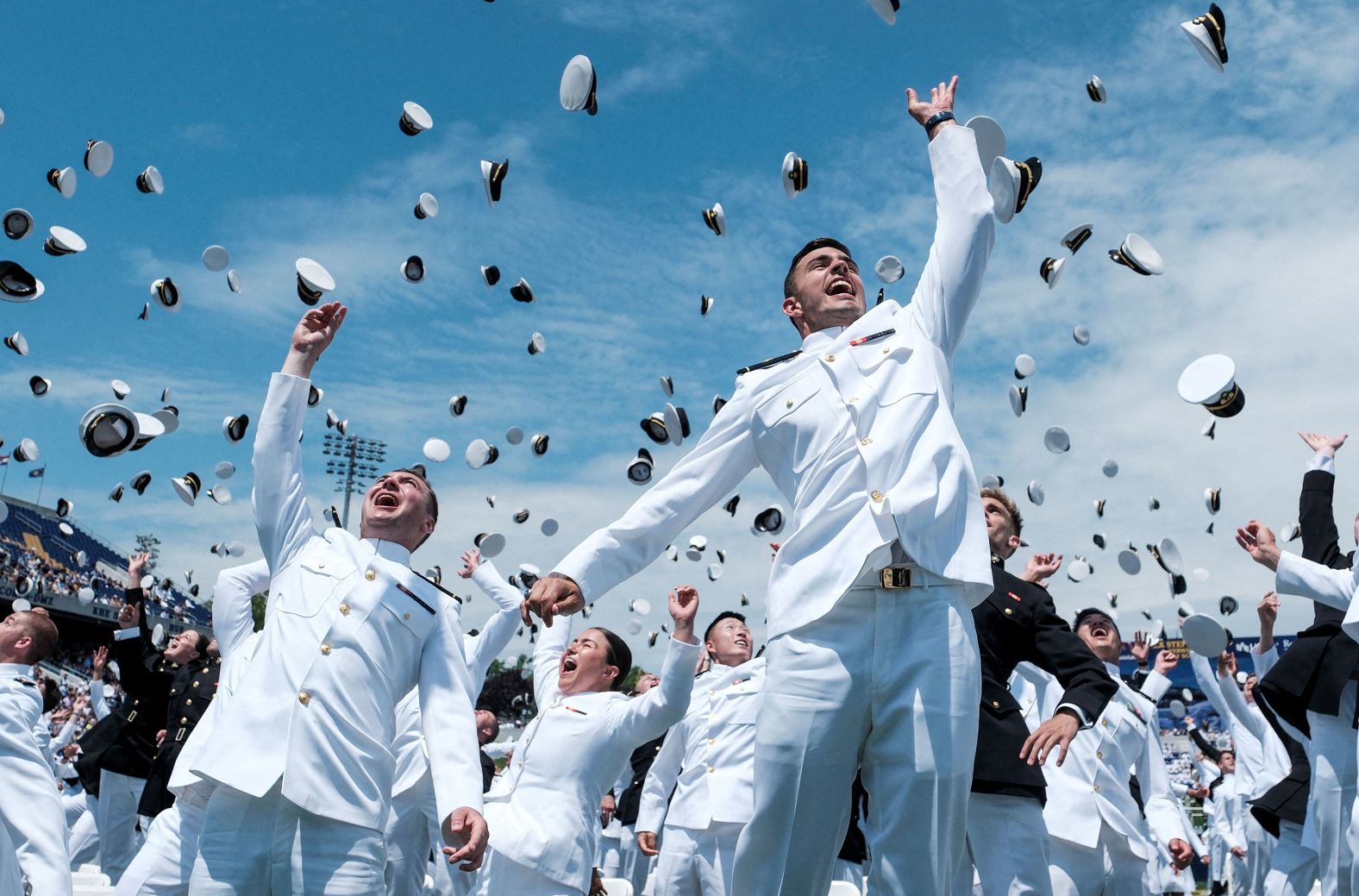 Midshipmen from the US Naval Academy toss their caps into the air Friday, May 24, during the commissioning and graduation ceremony in Annapolis, Maryland.