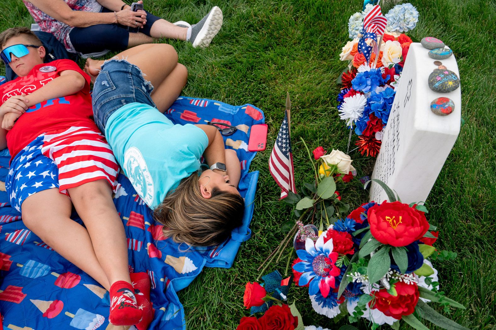 Sarah Schumann rests at the gravesite of her husband, Army Spc. Jordan Schumann, at Arlington National Cemetery in Arlington, Virginia, on Monday, May 27. It was Memorial Day in the United States.