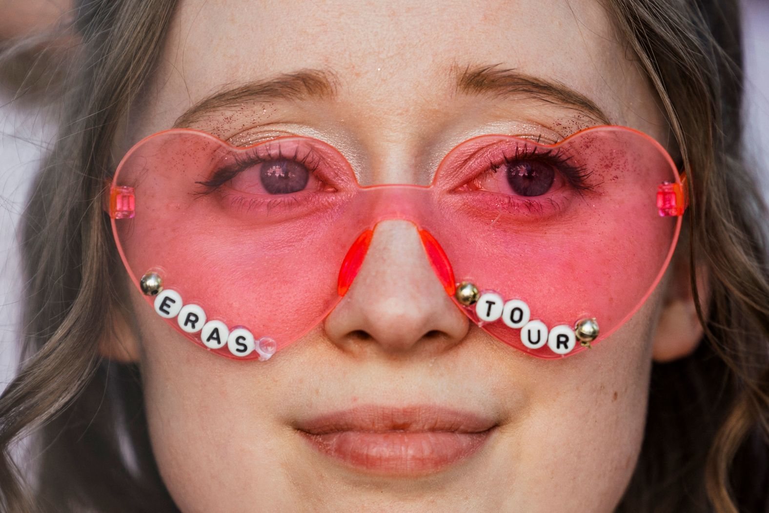 A fan sports <a href="index.php?page=&url=http%3A%2F%2Fwww.cnn.com%2F2023%2F08%2F04%2Fentertainment%2Fgallery%2Ftaylor-swift-eras-tour%2Findex.html" target="_blank">"Eras Tour"</a> glasses ahead of a Taylor Swift concert in Lisbon, Portugal, on Friday, May 24.