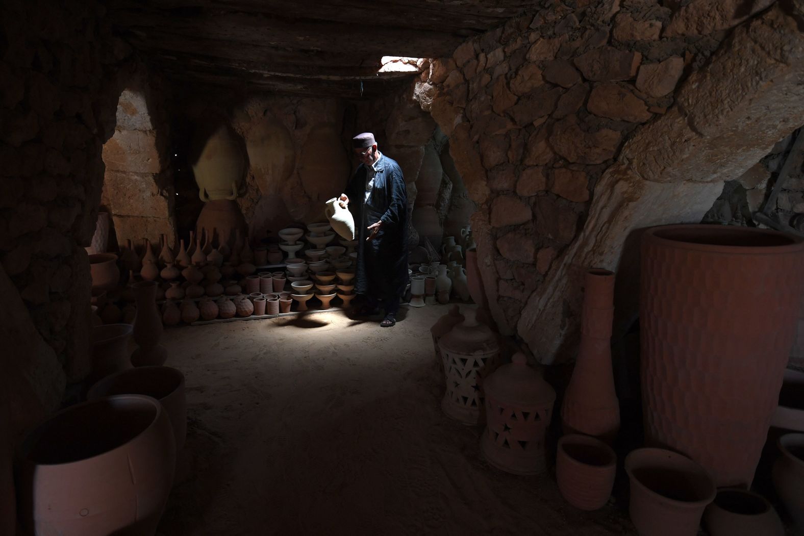 A man carries a pot at an 800-year-old pottery workshop in Guellala, a village on the Tunisian island of Djerba, on Saturday, May 25.