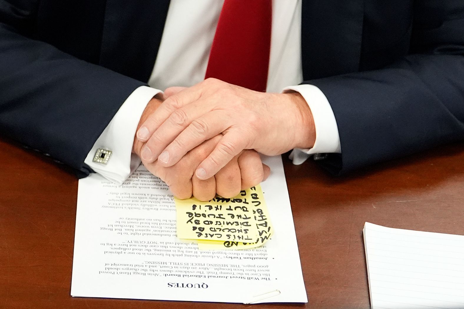 Notes are seen under Trump's hands as he awaits court proceedings on Tuesday, May 28.