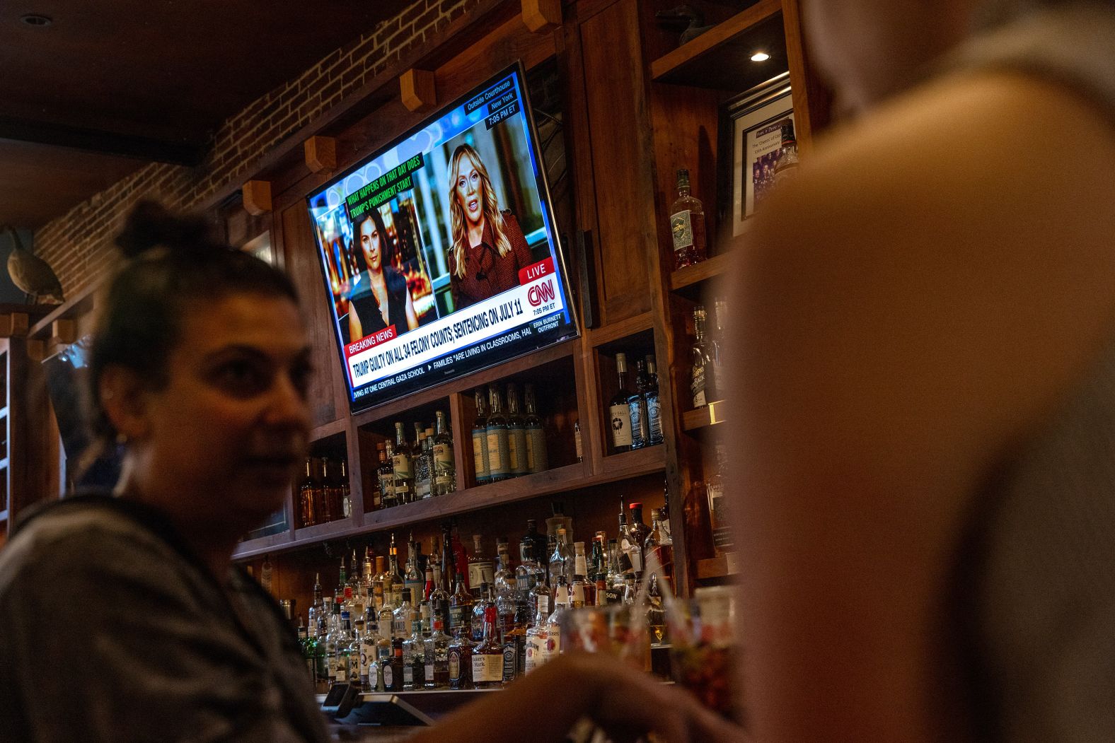 People eat and drink while CNN's coverage of the trial plays in the background at Hawk 'n' Dove in Washington, DC. 