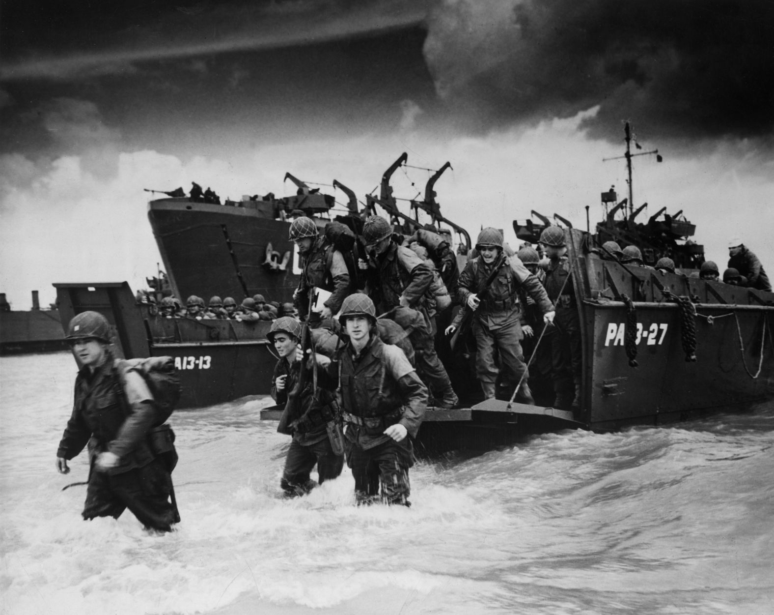 Reinforcements disembark from boats at Normandy.