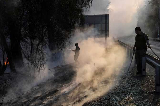 Israeli soldiers use a hose to extinguish flames by the side of a road close to the country's border with Lebanon on Tuesday, June 4. <a href="https://www.cnn.com/2024/06/05/middleeast/israel-lebanon-cross-border-tensions-escalate-intl/index.html" target="_blank">Cross-border attacks from Lebanon</a> led to large fires blazing through Israel's northern region this week, consuming swathes of land and leading to the evacuation of residents. Israel attributed the blaze to rocket fire from southern Lebanon, where the Iran-backed Islamist group Hezbollah said it had launched a "swarm of drones" at Israeli military sites. The Israeli military warned it was prepared to launch a large-scale attack to deter Hezbollah.