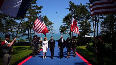 TOPSHOT - (From L) French President's wife Brigitte Macron, France's President Emmanuel Macron, US President Joe Biden and US First Lady Jill Biden arrive to attend the US ceremony marking the 80th anniversary of the World War II "D-Day" Allied landings in Normandy, at the Normandy American Cemetery and Memorial in Colleville-sur-Mer, which overlooks Omaha Beach in northwestern France, on June 6, 2024. The D-Day ceremonies on June 6 this year mark the 80th anniversary since the launch of 'Operation Overlord', a vast military operation by Allied forces in Normandy, which turned the tide of World War II, eventually leading to the liberation of occupied France and the end of the war against Nazi Germany. (Photo by Daniel Cole / POOL / AFP) (Photo by DANIEL COLE/POOL/AFP via Getty Images)