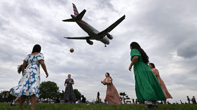 ARLINGTON, VA: - JUNE 02: A plane heading to Ronald Reagan Washington National Airport flies over congregants from Iglesia Evangelica Apostoles Y Profetas as they play volleyball at Gravelly Point after attending church on Sunday June 2, 2024 in Arlington, VA. (Photo by Matt McClain/The Washington Post via Getty Images)