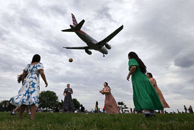 A plane flies over women playing volleyball after they attended church in Arlington, Virginia, on Sunday, June 2.