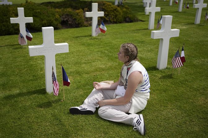 A woman sits by crosses at a US cemetery near Colleville-sur-Mer on Thursday.