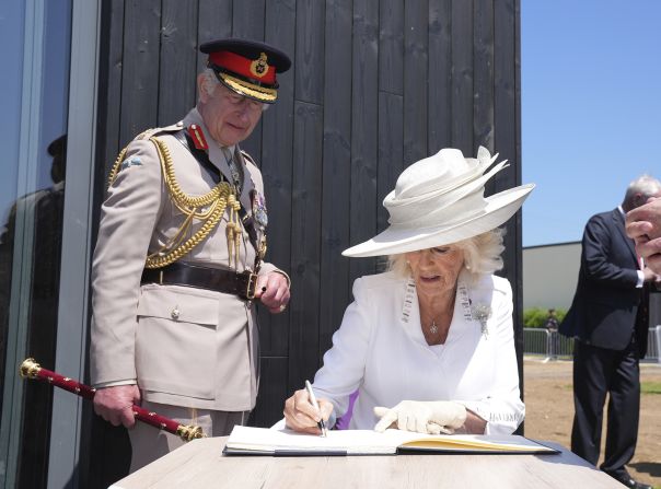 Britain's King Charles III watches Queen Camilla signs the guestbook at the official opening of the Winston Churchill Education and Learning Centre, on the site of the British Normandy Memorial in Ver-sur-Mer.