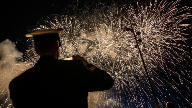 A UK soldier watches fireworks on June 6, 2024 in Arromanches-les-Bains, as part of the "D-Day" commemorations marking the 80th anniversary of the World War II Allied landings in Normandy. The D-Day ceremonies on June 6 this year mark the 80th anniversary since the launch of 'Operation Overlord', a vast military operation by Allied forces in Normandy, which turned the tide of World War II, eventually leading to the liberation of occupied France and the end of the war against Nazi Germany. (Photo by LOIC VENANCE / AFP) (Photo by LOIC VENANCE/AFP via Getty Images)